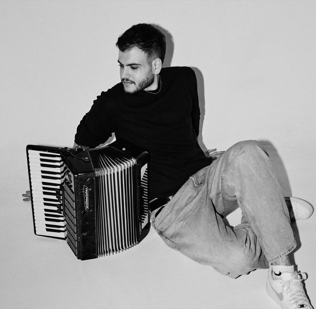 Alain Mékani sitting with his accordion